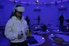 En person i vit tröja med VR headset på sig. Foto. 